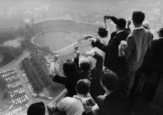 Univ. of Pittsburgh students cheering wildly from atop Cathedral of Learning on school's campus as they look down on Forbes Field where the Pittsburgh Pirates are winning their first World Series in 35 yrs. against the NY Yankees. George Silk